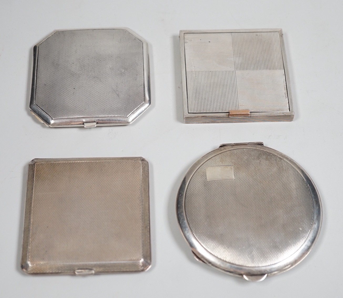 A George V Art Deco silver cigarette case, David Sutton & Sons, London, 1935, 65mm, with leather carrying case, together with three engine turned silver compacts.